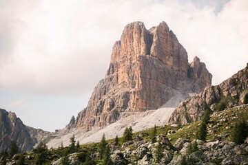Landscapes of epic mountains during the sunset surrounded by clouds, with warm and cold lights. huge cliffs and epic views from the wild nature. 