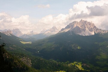 Fototapeta premium Landscapes of epic mountains during the sunset surrounded by clouds, with warm and cold lights. huge cliffs and epic views from the wild nature. 