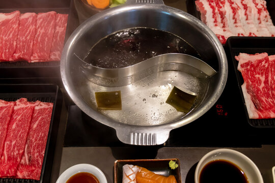 Shabu soup 2in1 in pot on table (Kombu seaweed and Sukiyaki soup) with delicious beef slide. Ready to eat with shabu shabu.