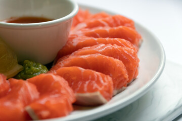 Fresh salmon sashimi serve on plate with spicy sauce. Japanese food style.