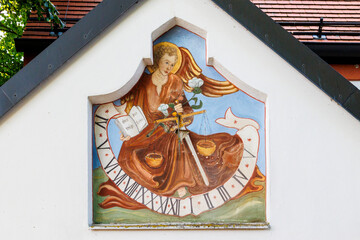 A sundial with a Christian painting and the German text God weighs life at the church of St Sebastian in Germany, Puch, 20 July 2024 © were