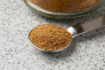 Metal spoon wit ground cumin close up