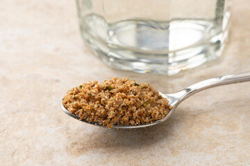 Spoon with ground garden herb bouillon powder close up