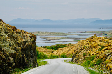 Road on the island of Leka surrounded by unique rock formations. Leka is designated as Norway's...