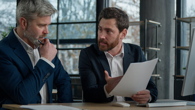 Two disgruntled furious Caucasian businessmen arguing about bad contract in office men colleagues partners dispute incorrect document failed transaction deal conflict problem shouting break agreement