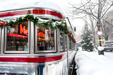 Obraz premium Retro diner decorated with Christmas garlands and lights in a snowy winter street