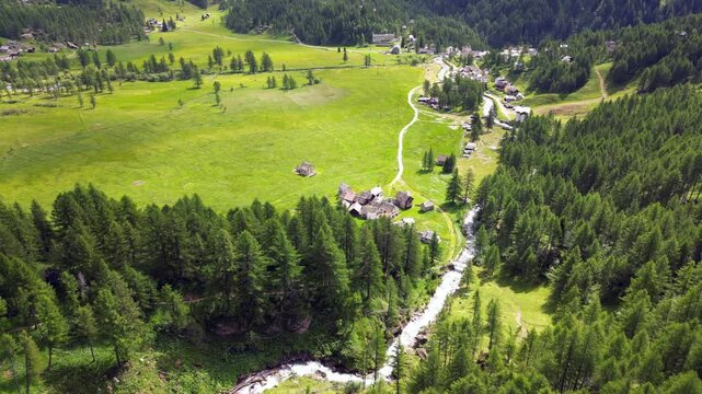 enchanted mountain village in summer with meadow of flowers seen from the drone -increase in tourism in mountain places to visit the ancient villages and go for walks in Alpe Devero,Ossola Apls Italy 