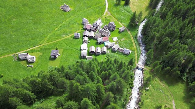 enchanted mountain village in summer with meadow of flowers seen from the drone -increase in tourism in mountain places to visit the ancient villages and go for walks in Alpe Devero,Ossola Apls Italy 
