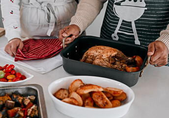 Hands, cooking and chicken in kitchen for celebration, holiday and dinner for event on counter. Food, potatoes and people for thanksgiving meal in home with nutrition, plate and vegetable for health
