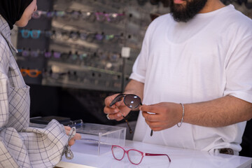 Arabic female wearing hijab is looking for new eyeglasses