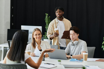 A diverse startup team collaborates in a bright office space.