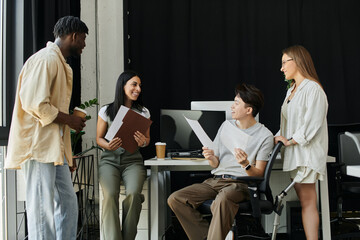 A diverse team of four works on a startup project, with one team member in a wheelchair