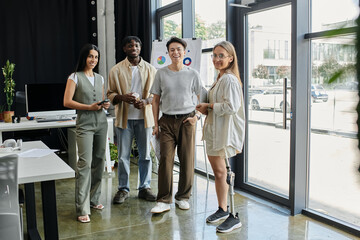 Four colleagues stand together in a bright office space.
