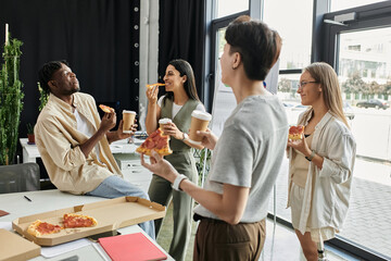 A group of four colleagues take a break from work, enjoying pizza and coffee together