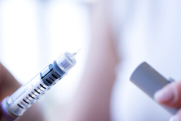 young woman holds a syringe for insulin