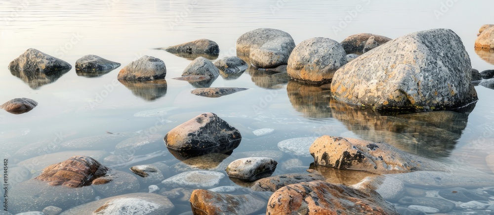 Poster Rocks made of granite scattered in the water creating a picturesque scene with copy space image