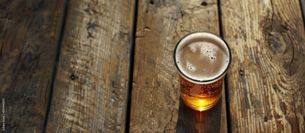 Poster a clear beer glass on a wooden surface with space for text and a copy space image