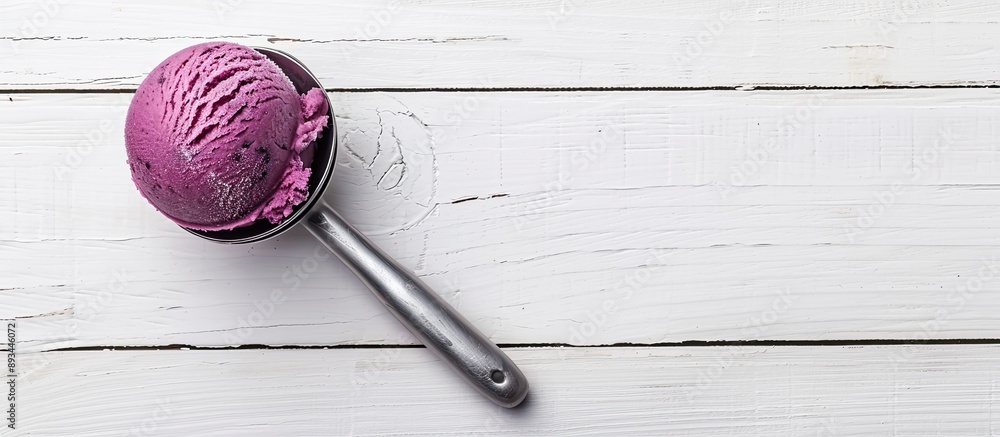 Poster side view of blueberry sorbet in an ice cream scoop on a white wooden surface offering empty space f
