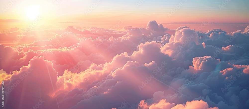 Poster A large expanse of sky filled with fluffy clouds the sun gently shining in the background providing a serene copy space image