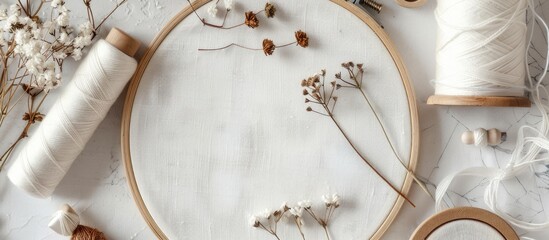 White fabric an embroidery hoop needles threads and cross stitch supplies on a copy space image