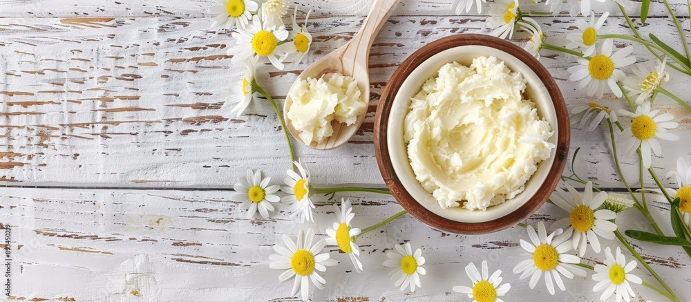 Poster white wooden background with shea butter and chamomile ideal for a copy space image
