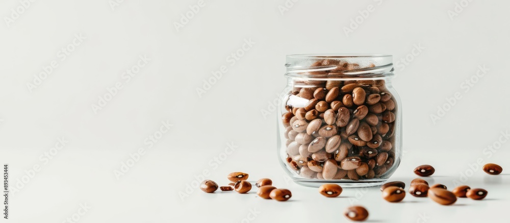 Aufkleber glass jar filled with raw beans on a white table background providing ample copy space for text