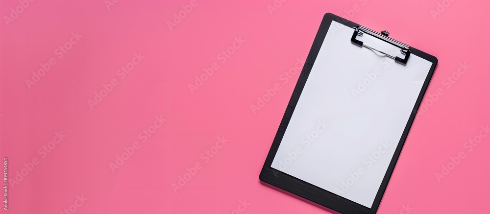Aufkleber top view of a black clipboard on a pink surface with a blank sheet of paper featuring ample copy spa