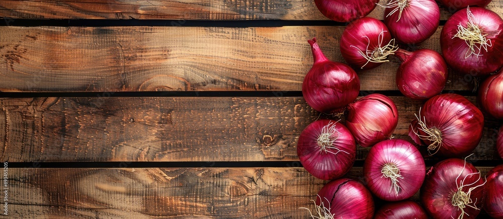 Poster Red Onions on a bright wooden surface creating a backdrop for text with a focused view from above suitable for a copy space image