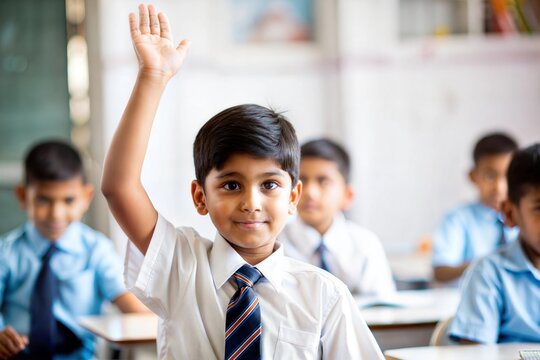 Indian schoolboy raising hand in classroom