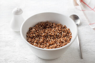 Bowl with boiled buckwheat on a white background. healthy homemade food