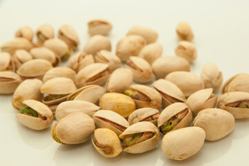 Shelled and unshelled pistachios on white background,hands holding some pistachios