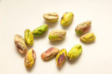 Shelled and unshelled pistachios on white background,hands holding some pistachios