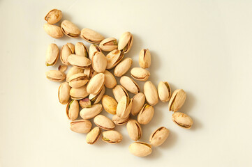 Shelled and unshelled pistachios on white background,hands holding some pistachios