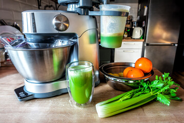 Fresh healthy celery juice and food processor with juicer on the kitchen table