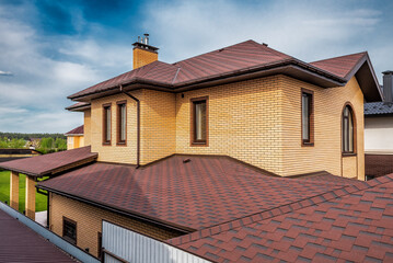 House with modern roof with new brown roof shingles