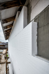 Plastered house wall with rigid styrofoam insulation. Modern technology, construction, renovation,...