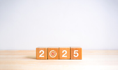 2025 Happy new year, simple horizontal banner. Numbers and target dart icon on wooden cube blocks isolated on wood table, white background with copy space. 2025 Business goal plan, eco style concept.