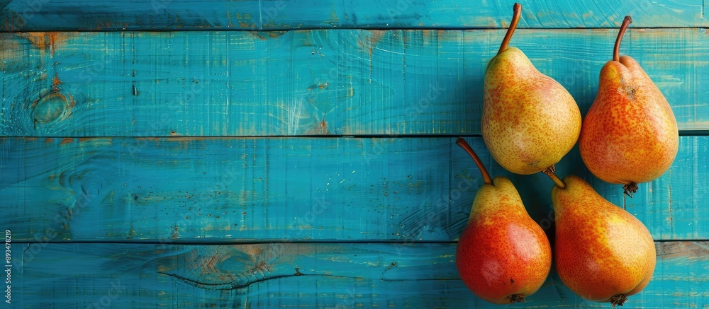 Poster ripe conference pears on a vibrant blue wooden background for an autumn harvest with space for text 