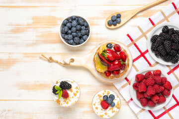 Sweet desserts with fresh berries on wooden background.