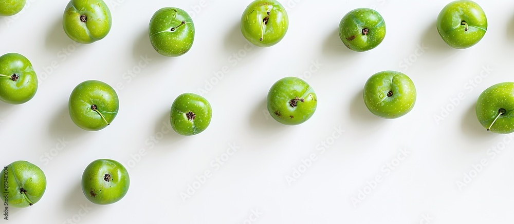 Poster Overhead shot of green pluots on a white backdrop with a blank area for text or images in the frame. copy space available
