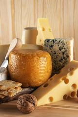 Assortment of different cheese types on wooden table. Cheese background.