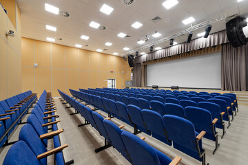 Empty auditorium hall. Conference room interior with a stage and blue chairs