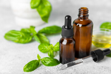 Basil essential oil on a textured wooden background. Basil essential oil and fresh leaves. Aromatherapy. Aroma oil. Medical herbs. Alternative medicine. Place for text. Copy space.