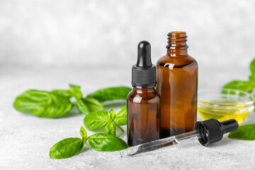 Basil essential oil on a textured wooden background. Basil essential oil and fresh leaves. Aromatherapy. Aroma oil. Medical herbs. Alternative medicine. Place for text. Copy space.