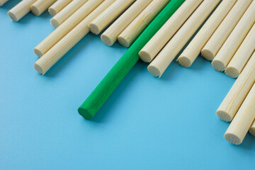 A unique green stick among abstract wooden ones.