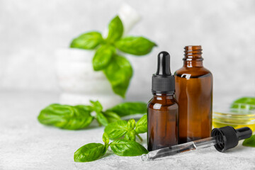 Basil essential oil on a textured wooden background. Basil essential oil and fresh leaves. Aromatherapy. Aroma oil. Medical herbs. Alternative medicine. Place for text. Copy space.