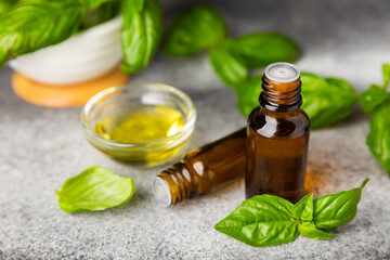 Basil essential oil on a textured wooden background. Basil essential oil and fresh leaves. Aromatherapy. Aroma oil. Medical herbs. Alternative medicine. Place for text. Copy space.
