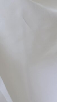 White fabric background waving gently, creating a soft, airy, and elegant tulle effect