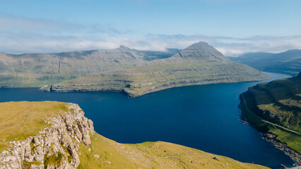 Funningur village, Faroe Islands. Sunny day in summer. Amazing nature in Faroe Islands. Eysturoy Island. Gonguturur or Hvithamar Trailhead. Faroese fjord and summits