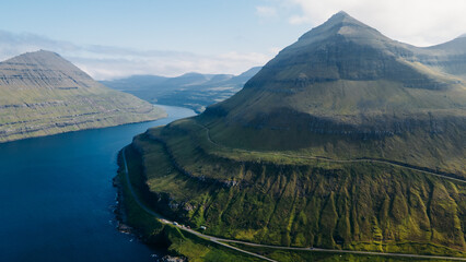 Funningur village, Faroe Islands. Sunny day in summer. Amazing nature in Faroe Islands. Eysturoy Island. Gonguturur or Hvithamar Trailhead. Faroese fjord and summits